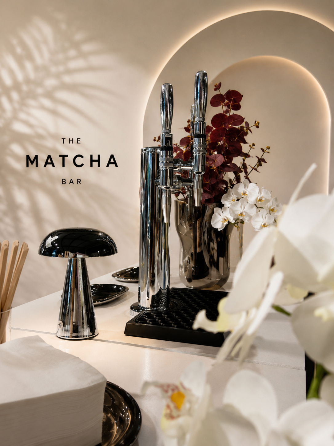 Close-up of the Yield matcha bar tap tower, cups and floral styling
